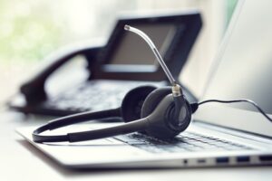 Headset headphones telephone and laptop in call center representing DIA